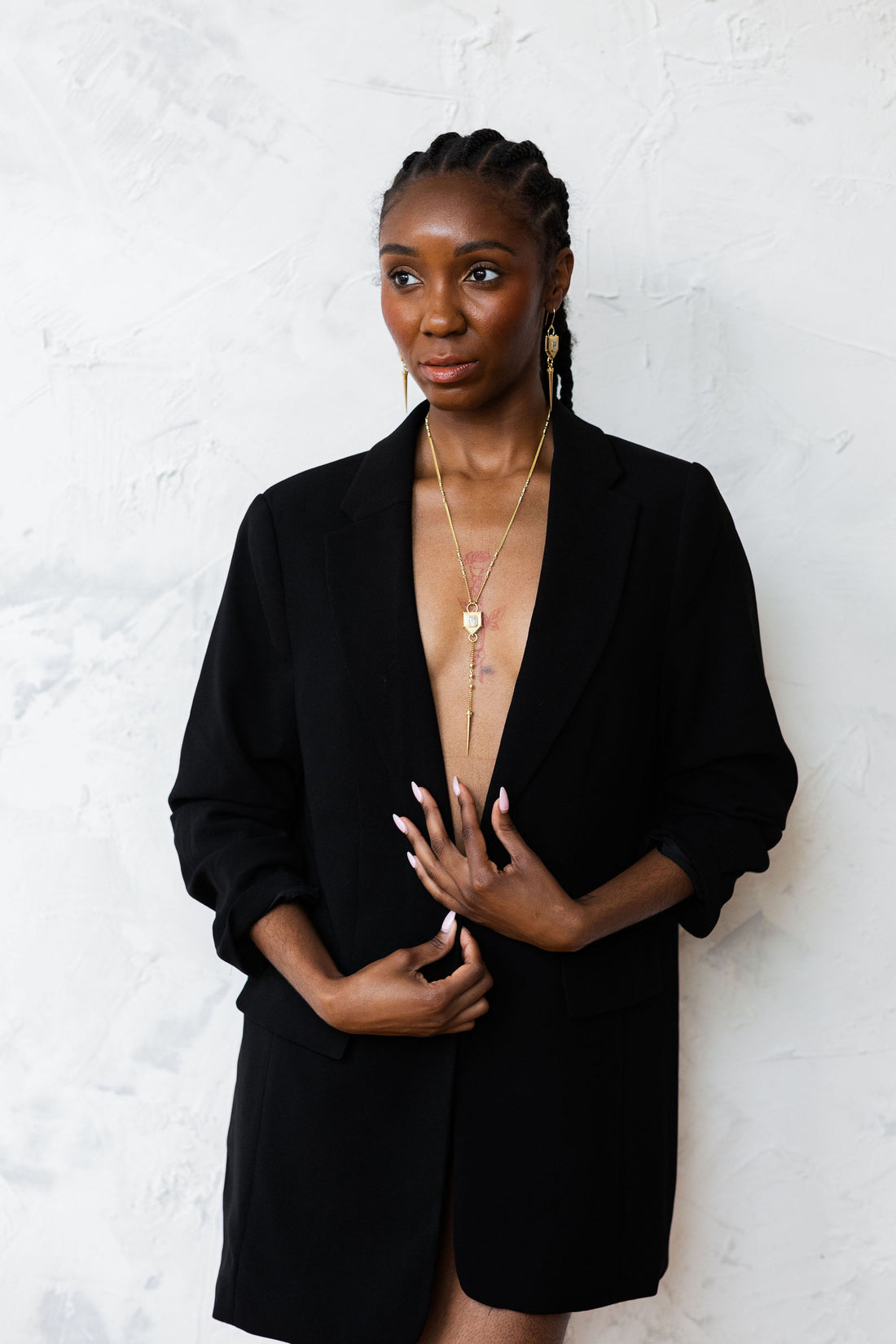 Model on white background in blazer with lariat necklace